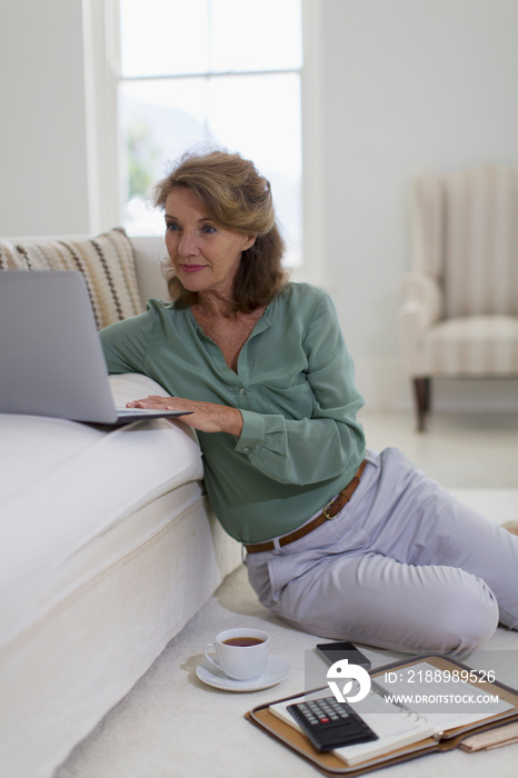 Senior woman using laptop in living room