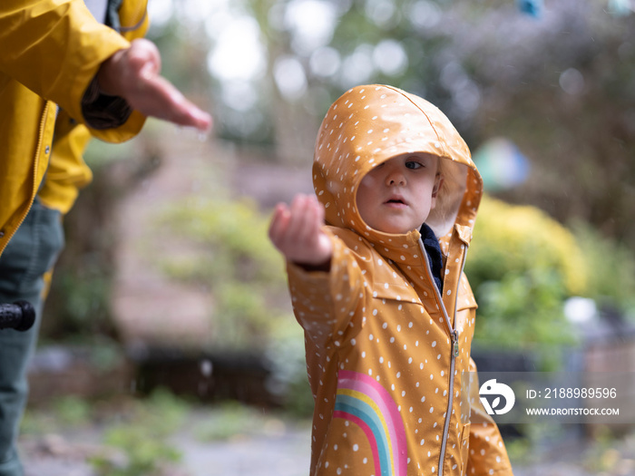 Mother and daughter catching rain drops�