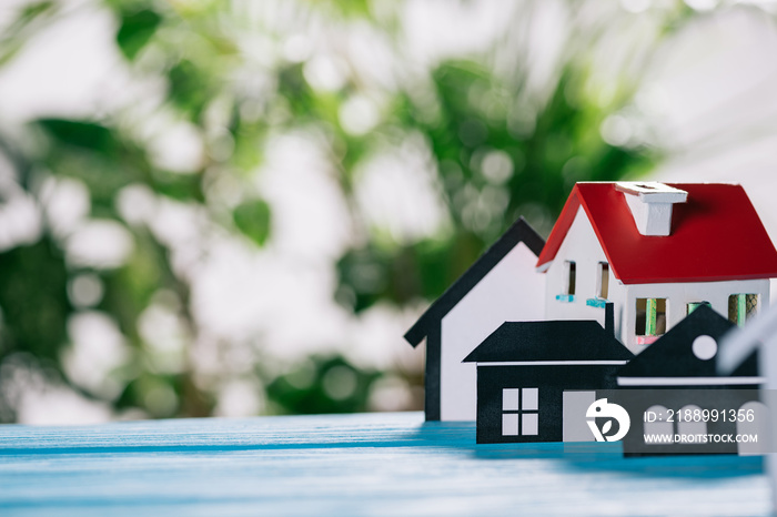 selective focus of paper houses and house model on wooden desk, mortgage concept