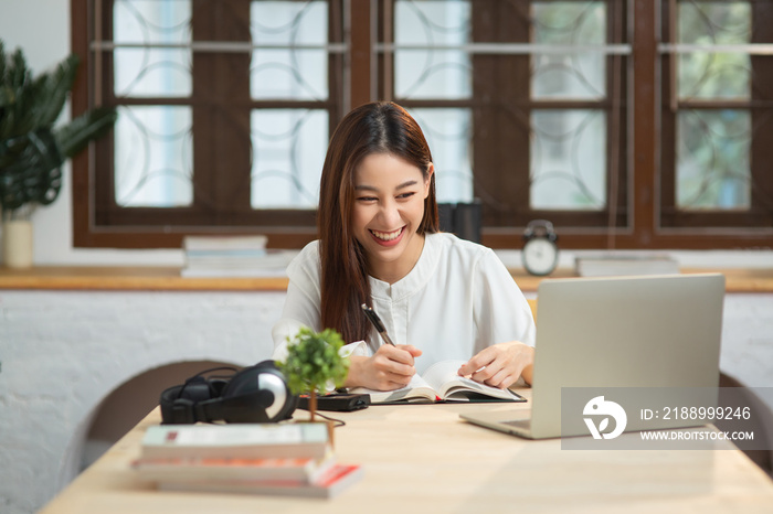 微笑的年轻企业家中国女商人在公寓里用电脑上网