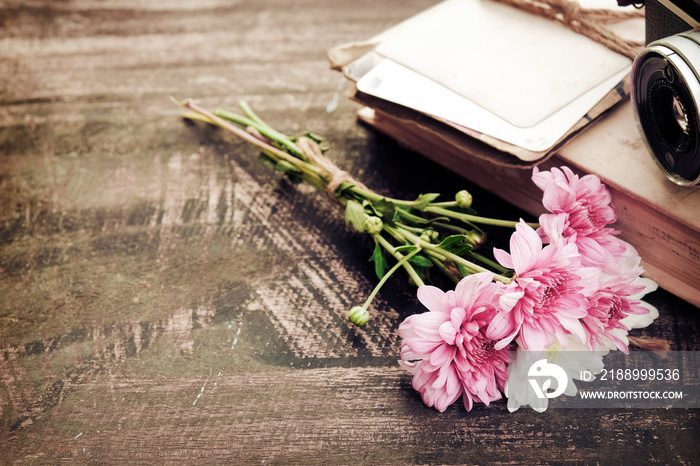 Vintage camera with bouquet of flowers on old wood background - concept of nostalgic and remembrance