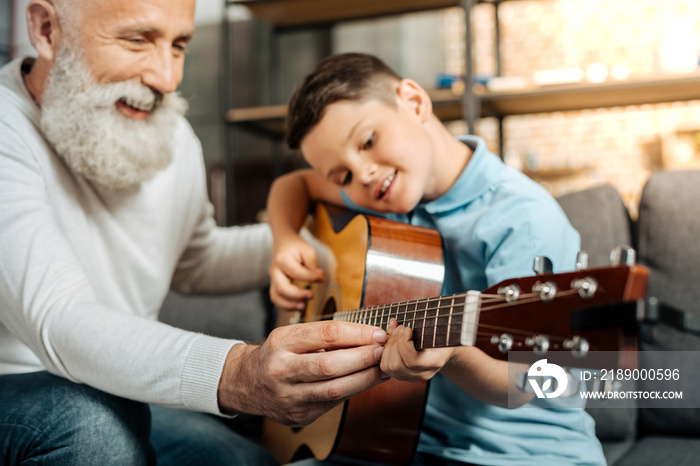 微笑的爷爷教孙子弹吉他