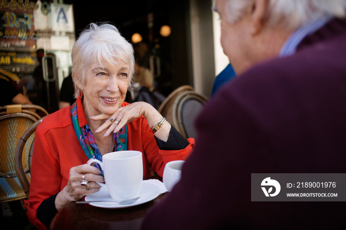 Senior couple talking at sidewalk cafe