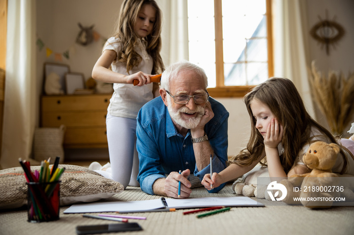 Happy elderly man drawing with kids stock photo