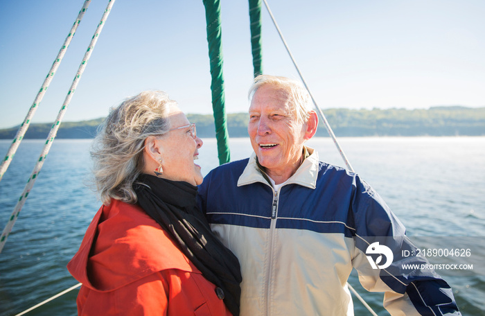 Laughing senior couple on sailboat