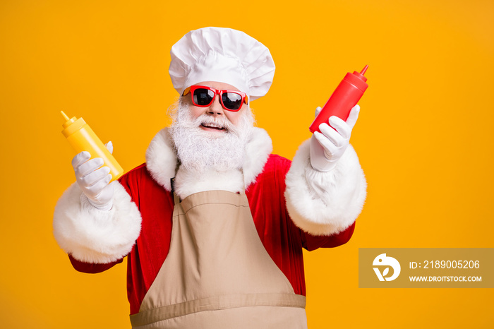 滑稽的圣诞老人戴着厨师头戴着厨师圣诞大餐拿着芥末番茄酱瓶子