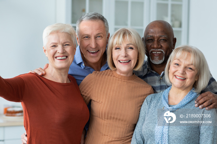 Positive senior people taking selfie together, kitchen interior