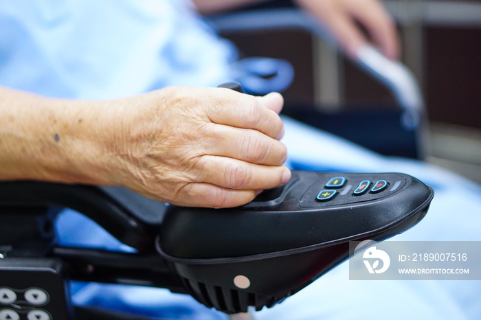 Asian senior or elderly old lady woman patient on electric wheelchair with remote control at nursing