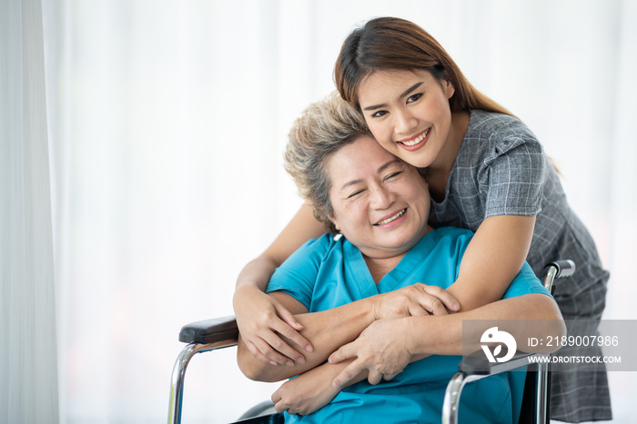 Asian daughter or care assistant helping support senior woman or mother