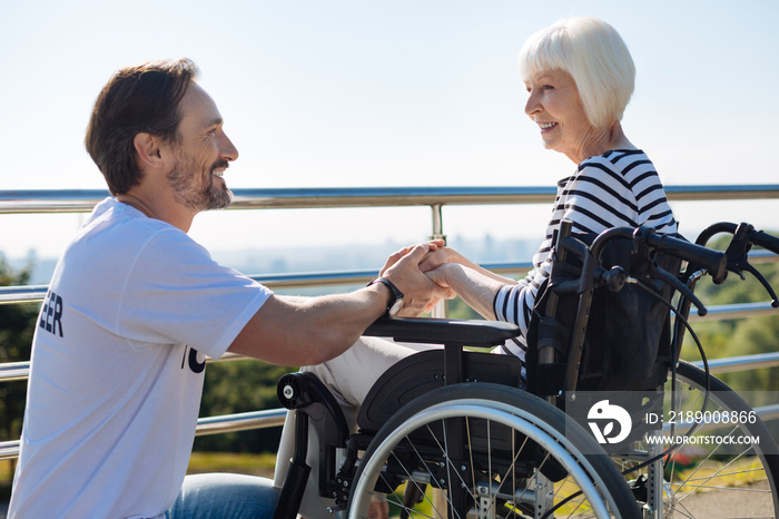 Charismatic creative volunteer supporting elderly lady