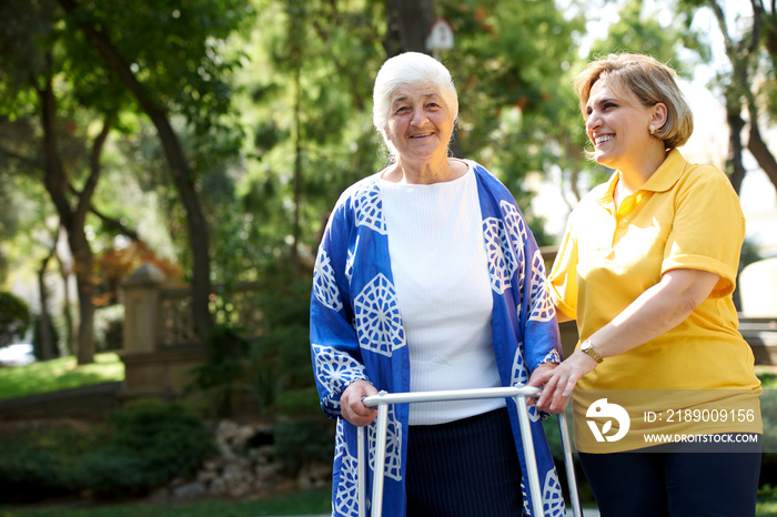 Health visitor and a senior woman during visit, outdoors