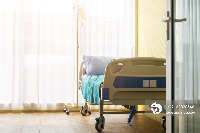 Empty patient bed in room of hospital.