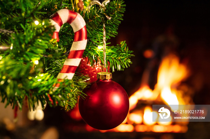 Christmas tree close up on blurred burning fireplace background