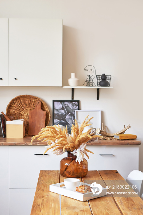 Cozy interior of bright loft style kitchen. White kitchen set. Kitchen accessories. Shelves and dish