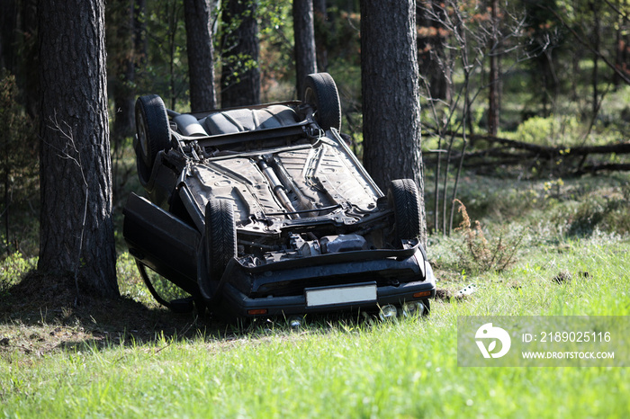 Car accident place on a bend, overturned car lies on the roof