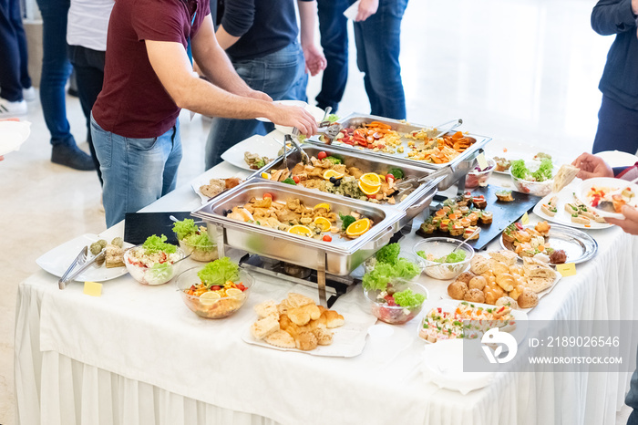 People enjoying buffet meal at the table.