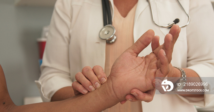 Close-up of doctor checking male patients pulse on his wrist. Close up of senior medical doctor appl