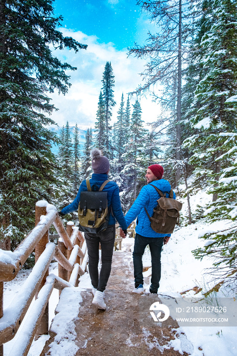 加拿大阿尔伯塔省路易斯湖附近的艾格尼丝湖。情侣们在卢湖畔的森林里与雪一起徒步旅行