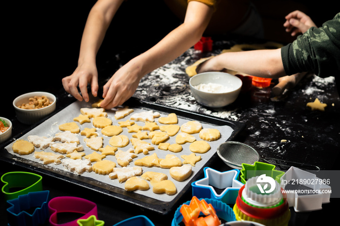 孩子们把饼干放在烤纸上。为节日烹饪不同形式的饼干。