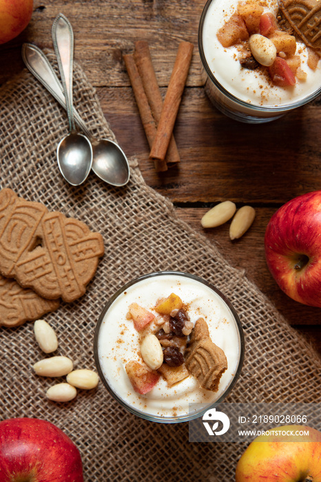 Kuchen im Glas mit Stücken vom Bratapfel, Zimt, Spekulatius, Apfel, Mandeln und Rosinen mit einer Cr