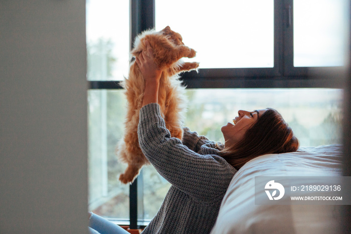 女人在家和她的猫玩游戏