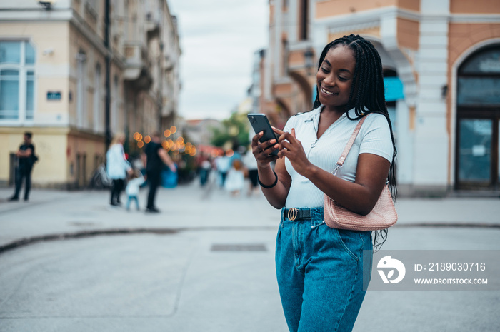 African american woman using smartphone while touring the city