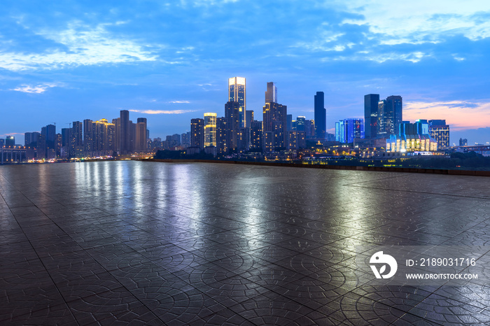 中国重庆，夜晚，空旷的广场层和城市天际线，建筑林立。