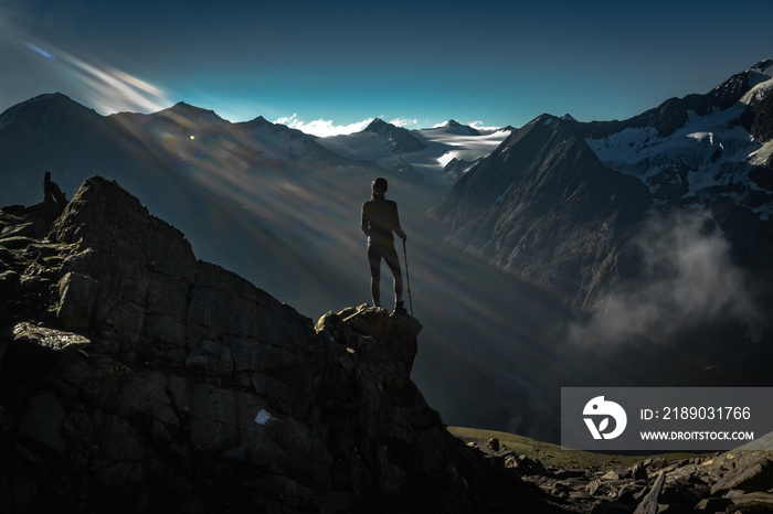 woman looking on the first sunrise light beams from sun in the alps Austria 