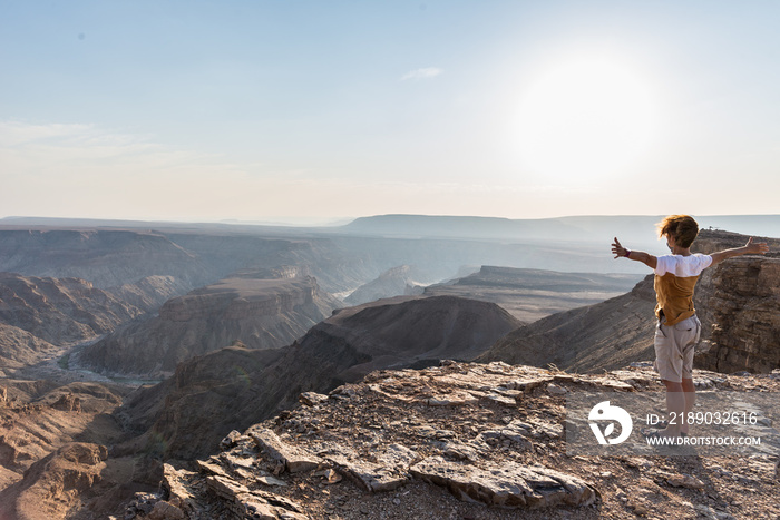 Rear view of tourist looking at expansive view over the Fish River Canyon, scenic travel destination