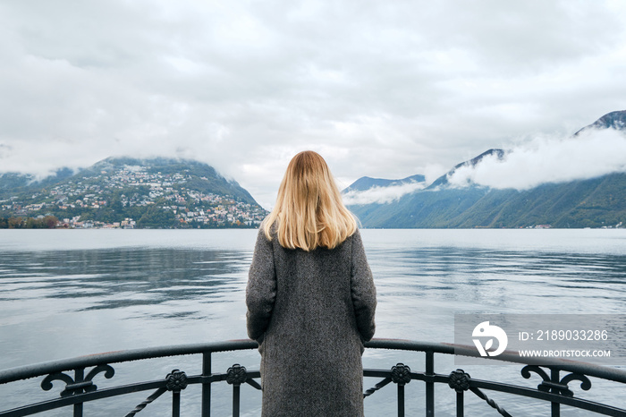 美丽的高加索女人站在卢加诺的码头上。旅行中的女孩。卢加诺湖，A南坡