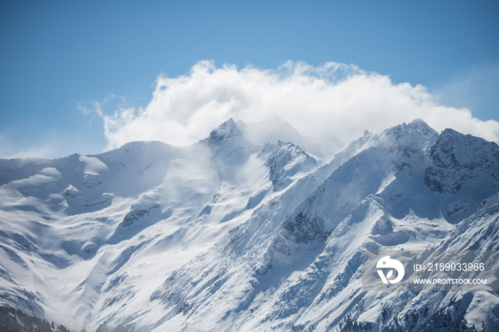 多云天空下的冬季雪山风景