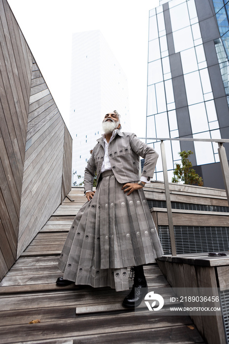 smiling gray hair bearded man wearing skirt suit in city location