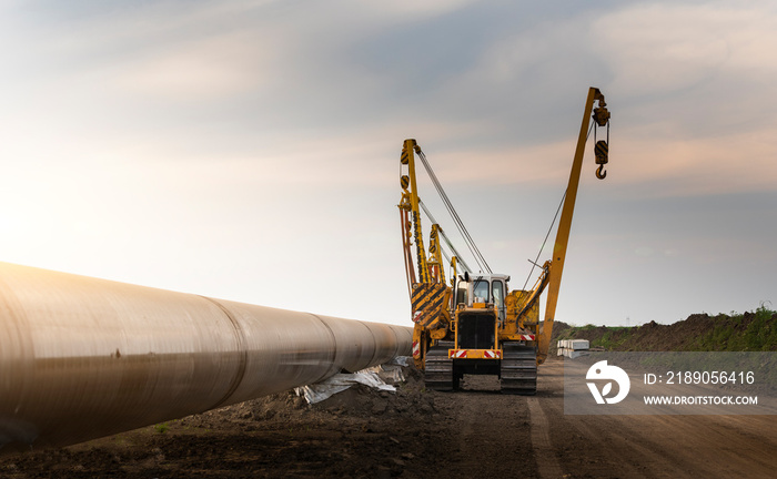 Crane digging a channel for gas pipeline