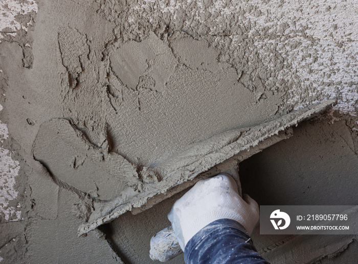 Worker plastering tool plaster marble on interior plaster rough