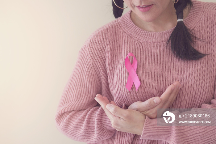 woman wearing pink top with pink ribbon, breast cancer awareness, October pink, World cancer day con