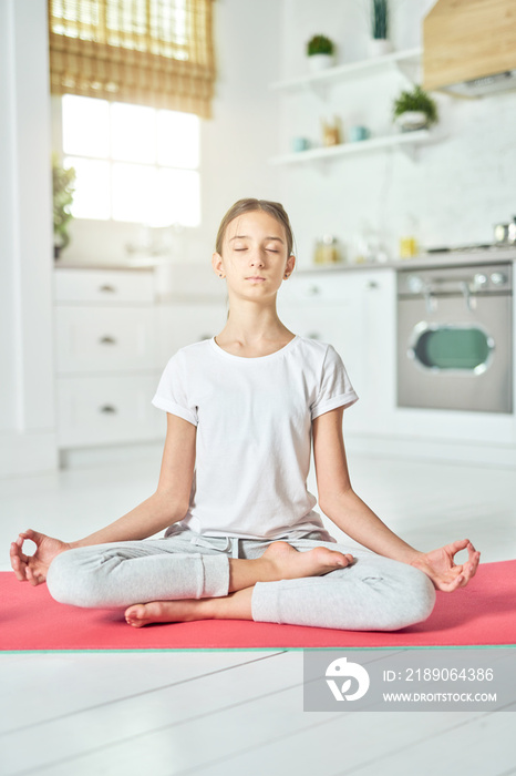 Revitalizing experience. Sporty relaxed hispanic teenage girl in sportswear looking calm while pract