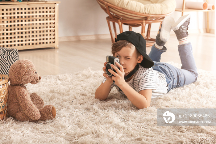 Cute little photographer with professional camera at home