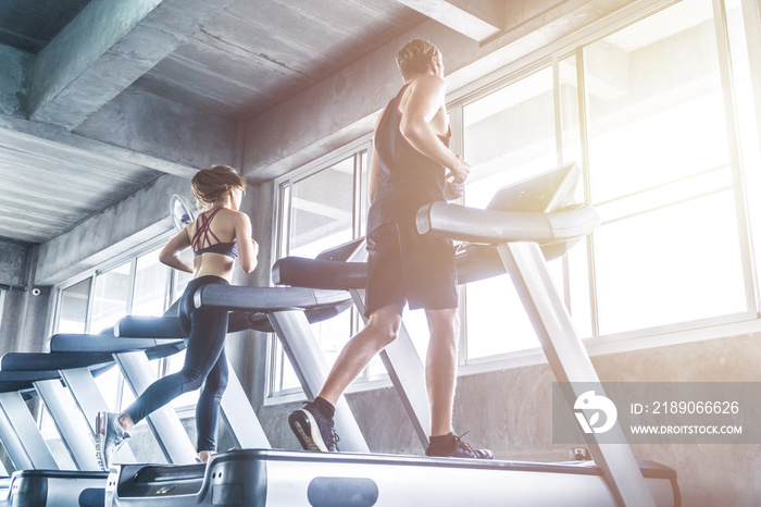 Two people in sportswear running on treadmills. Jogger exercise gym cardio workout concept.