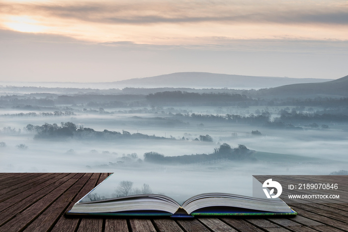 Stunning foggy English rural landscape at sunrise in Winter with layers rolling through the fields c