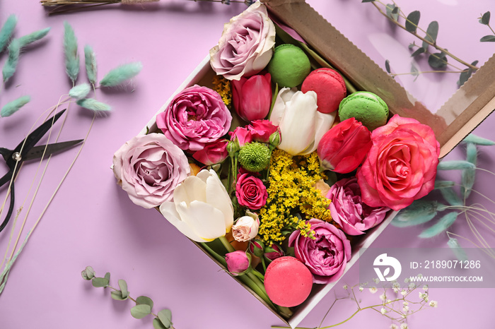 Gift box with beautiful flowers and macarons on color background