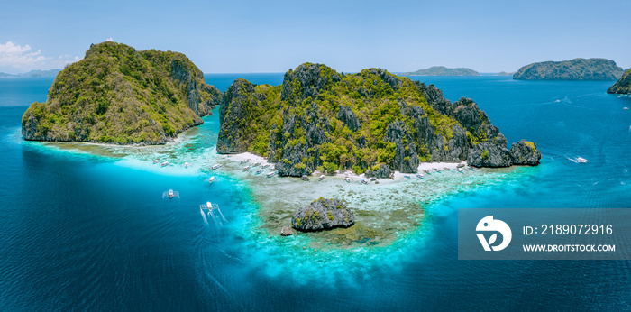 Aerial drone view of tropical Shimizu Island steep rocks and white sand beach in blue water El Nido,