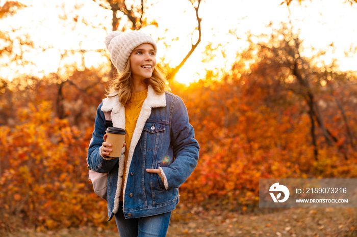 Lovely happy young girl walking in the autumn park