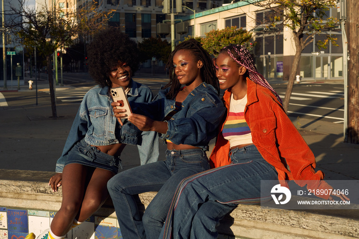 Portrait of young friend group together in the city on the phone taking selfies  