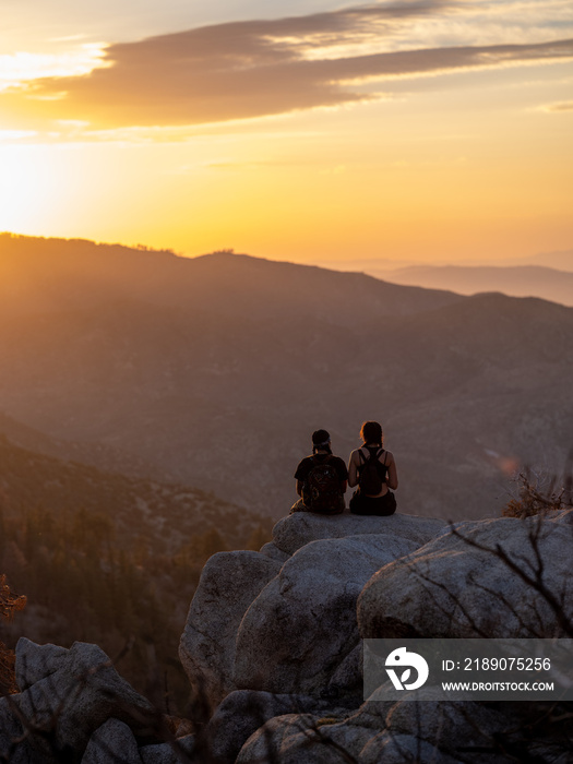 日落时，年轻的本地朋友眺望山脉的垂直图像