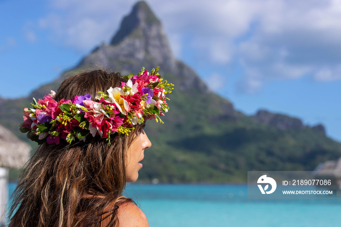 Beautiful woman wearing colorful flower crown while on a tropical island vacation in Bora Bora near 