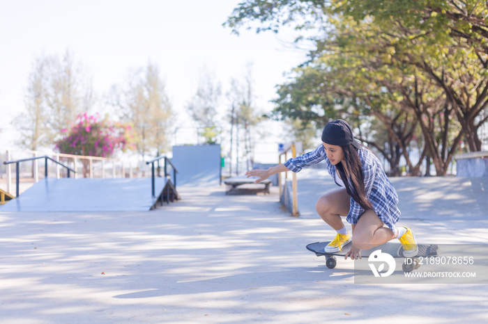 Young asian women play surf skate board at park skate ramp outdoors on morning. Happy women play sur