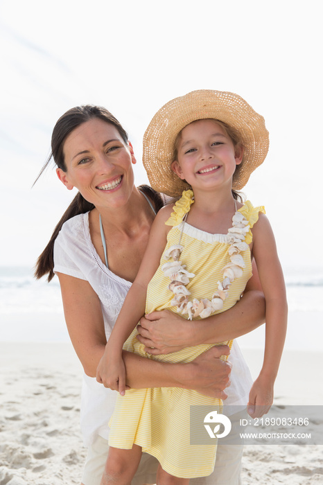 Portrait happy mother and daughter on sunny beach