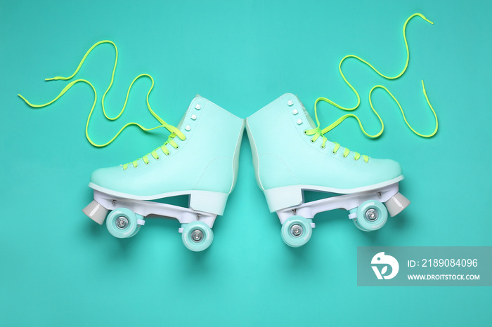 Vintage roller skates on color background