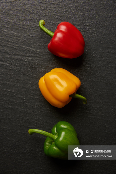 蔬菜概念三种不同颜色的甜椒躺在深色背景上