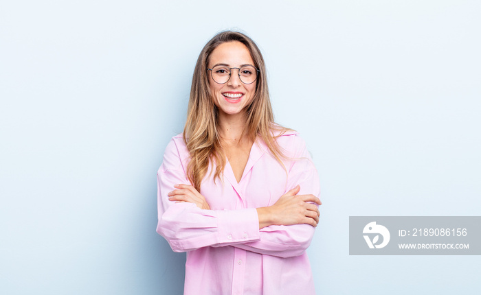 pretty caucasian woman looking like a happy, proud and satisfied achiever smiling with arms crossed